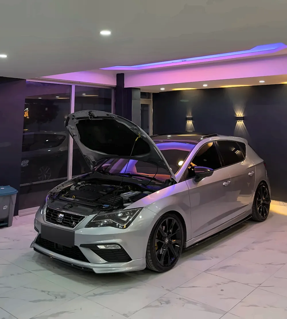 Stüdyoda mor LED tavan ışıkları altında kaputu açık gümüş Seat Leon