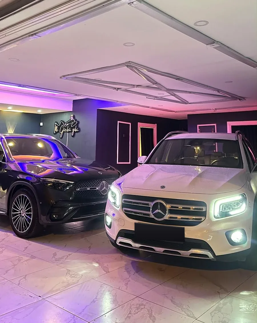 Tuzla'daki YıCar Detailing stüdyosunda siyah Mercedes GLC ve beyaz Mercedes GLB, arkada İlk Günkü gibi neon tabelası